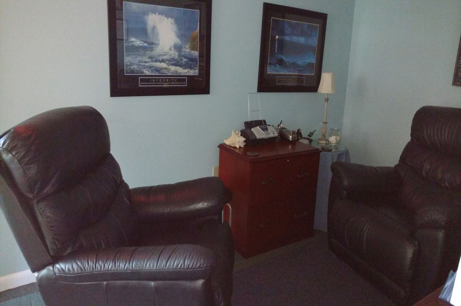 A living room with two pictures on the wall